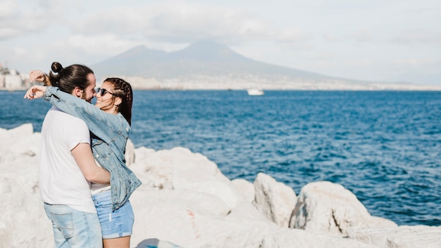 Free photo couple and summer concept on rocks by the sea