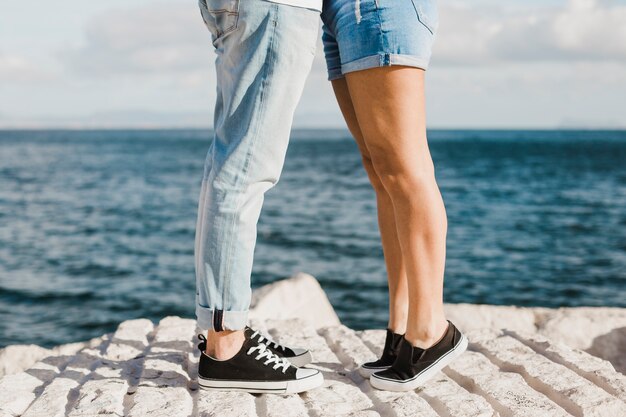 Пара и летняя концепция с ногами перед морем