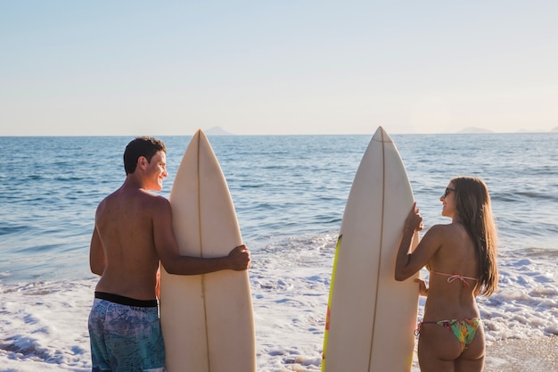 Free photo couple of surfers on the beach