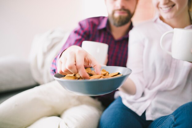 Couple taking cookies from bowl