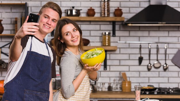 Couple taking photo with vegetable salad 