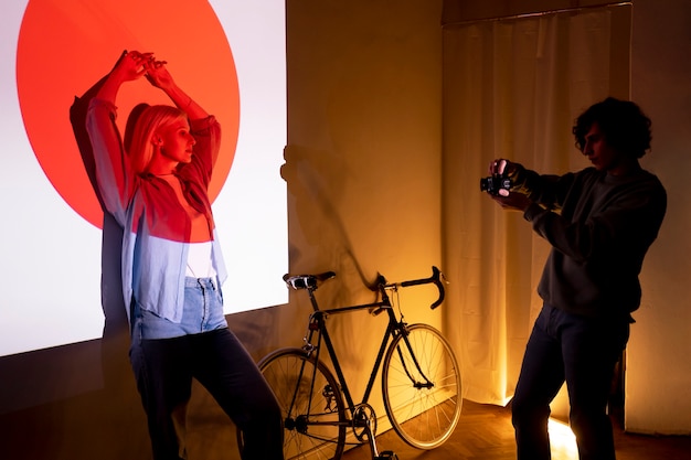 Free photo couple taking photos in the light of movie projector