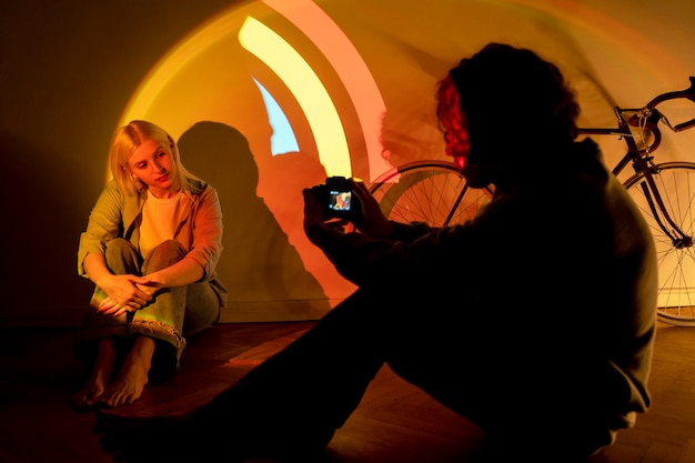 Free photo couple taking photos in the light of movie projector