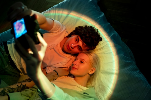 映写機の光の中で写真を撮るカップル