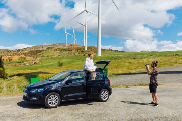 Couple taking photos with car outdoors