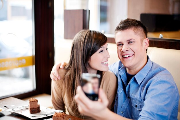 Пара фотографируется в кафе