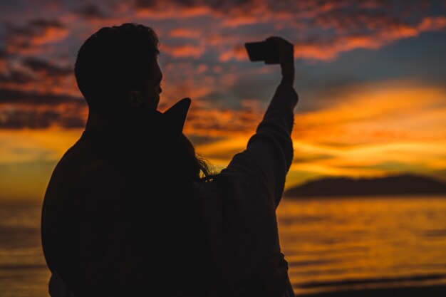 Couple taking selfie on night sea shore 