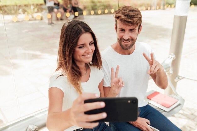 Couple taking a selfie and showing peace sign