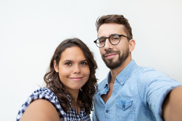 Couple taking selfie and smiling at camera