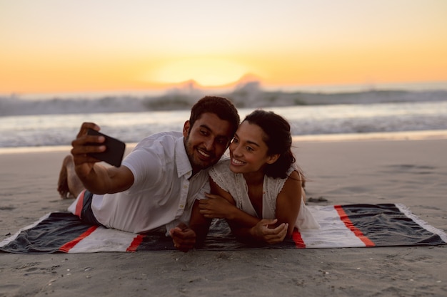 Пара, делающая селфи с мобильным телефоном на пляже