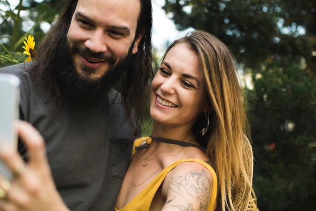 Free photo couple taking a selfie with sunflowers