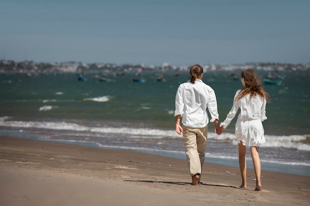 Couple taking a walk on the beach during vacation