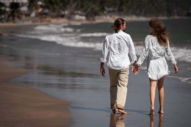 Пара гуляет по пляжу во время отпуска