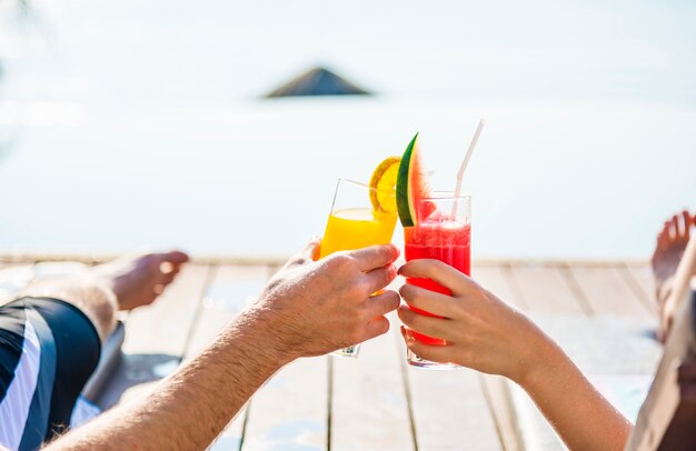 Couple toasting with cocktails by the pool