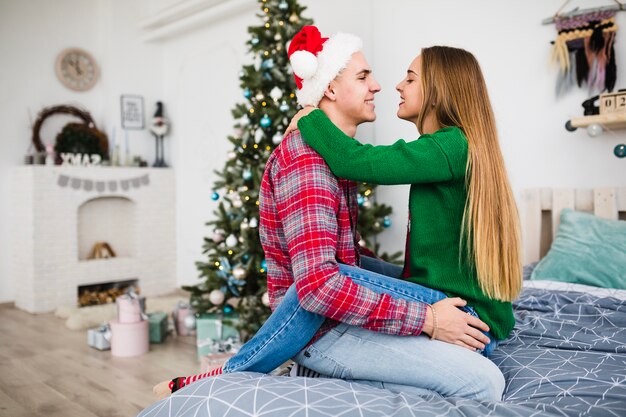 Couple together on bed at christmas