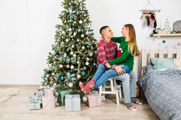 Couple together next to christmas tree
