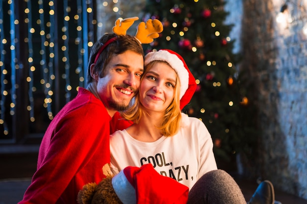 Couple together in front of christmas tree