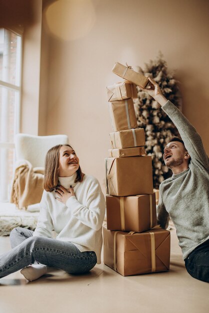 クリスマスプレゼントを一緒に保持しているカップル