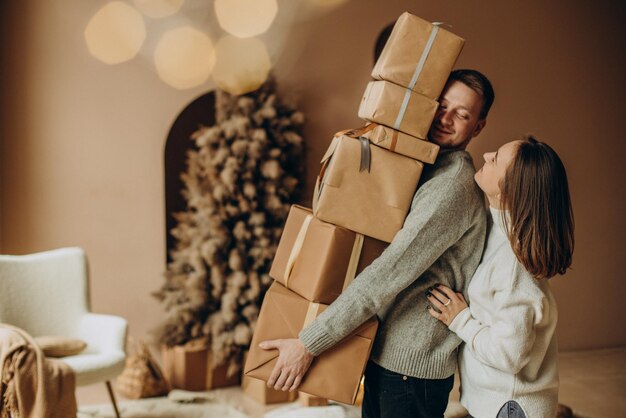 クリスマスプレゼントを一緒に保持しているカップル