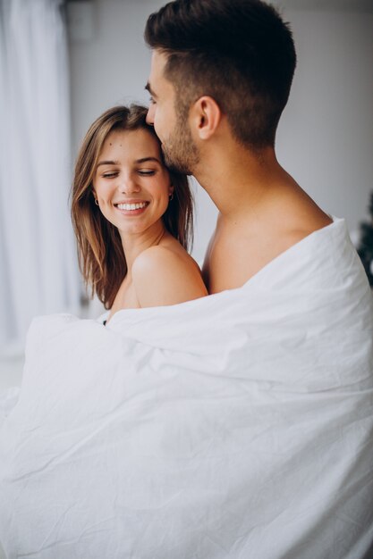 Couple together hugging under white blanket