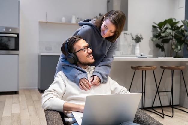 Couple together in the kitchen working on laptop