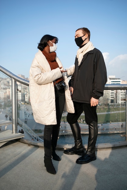 Couple of tourists outdoors in the city with medical masks