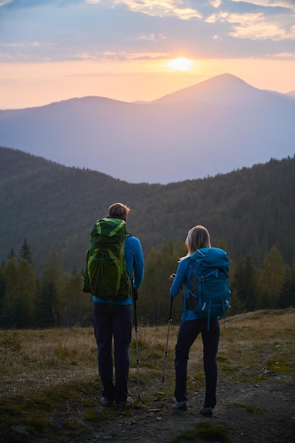 Free photo couple of travelers hiking in the mountains