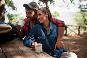 Free photo couple traveling in nature and enjoying a beverage