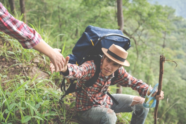 Couple on a trekking day in tropical forest along with backpacks in the forest, Adventure, travel, tourism, hike.