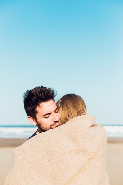 무료 사진 해변 담요 아래 커플