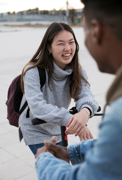 무료 사진 운송을 위해 전기 스쿠터를 사용하는 커플