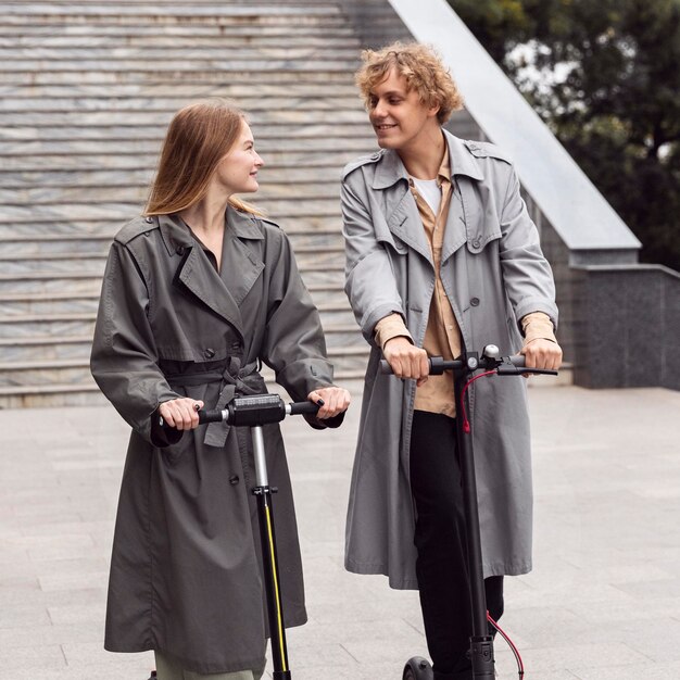 Couple using electric scooter outdoors together