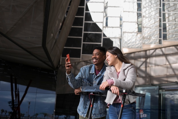 Free photo couple using electric scooter for transportation