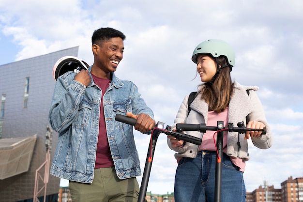 Free photo couple using electric scooter for transportation