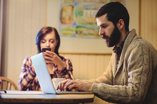 Couple using laptop and mobile phone