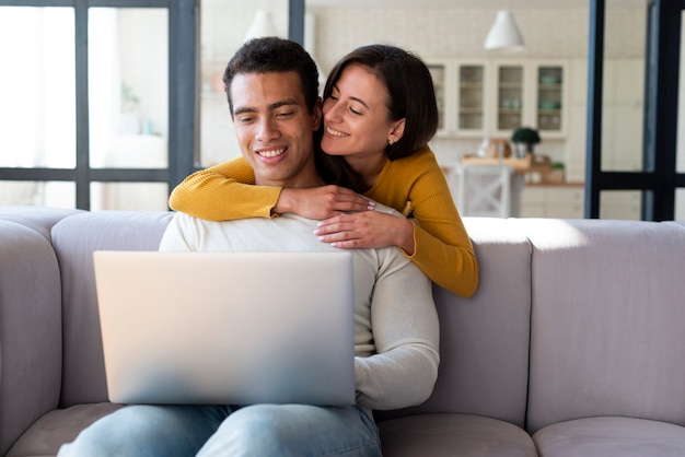 Free photo couple using laptop on a sofa