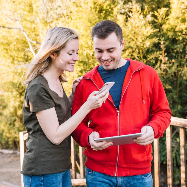 Couple using smartphone and tablet together