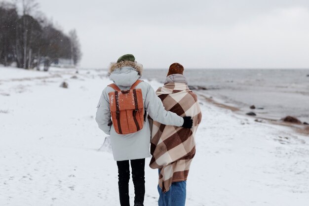 Couple waking by the beach together while on a winter road trip