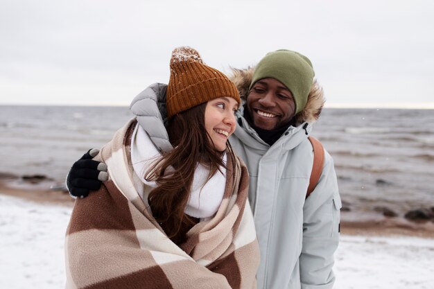 Couple waking by the beach together while on a winter road trip