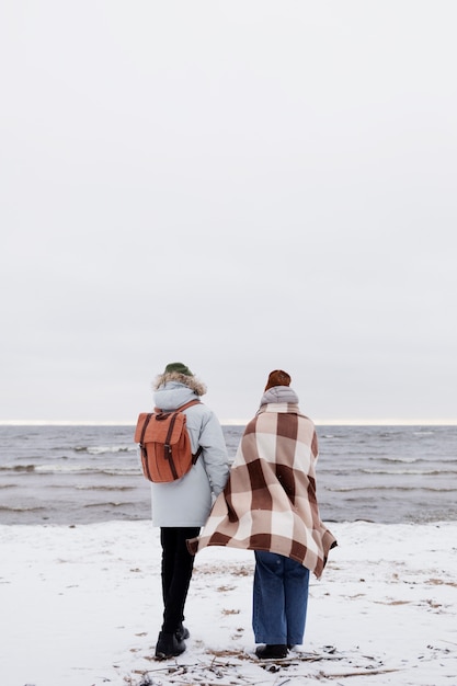 겨울 여행을 하는 동안 해변에서 함께 깨어난 커플