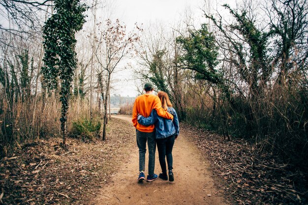 Couple walk together on gravel forest trail