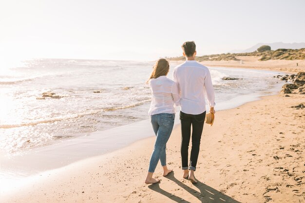 Пара гуляет по пляжу