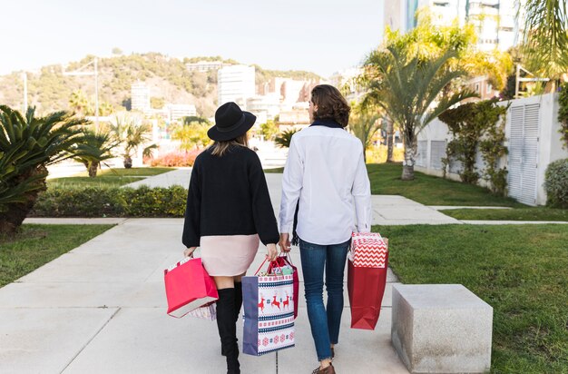 Couple walking in park with shopping bags