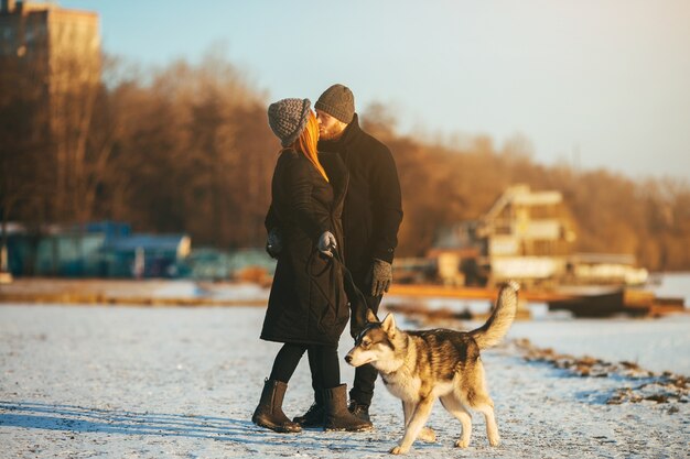 Couple walking their dog while they kiss