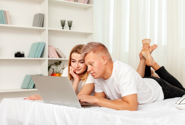Пара смотрит фильм на своем ноутбуке в постели