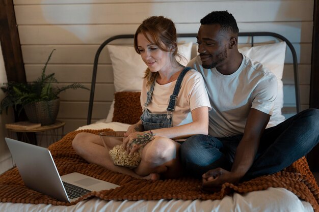 Couple watching streaming service together in the bedroom