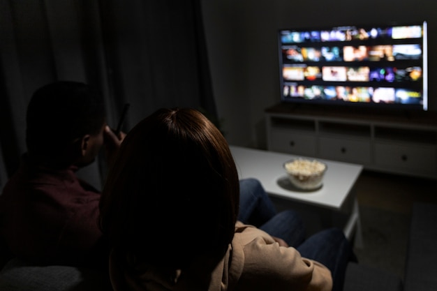 Free photo couple watching streaming service together at home indoors