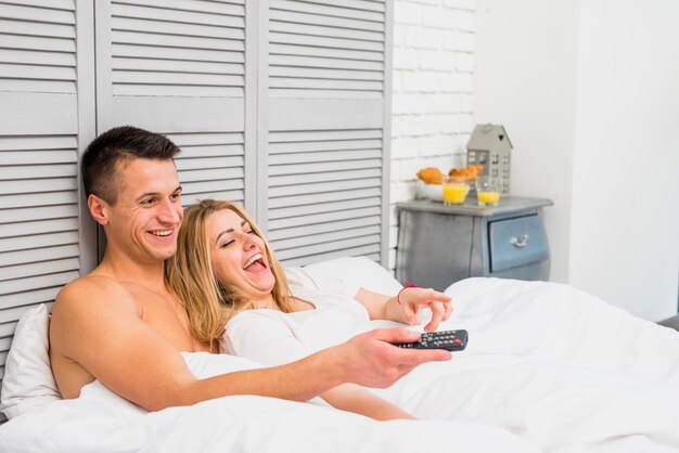 Couple watching TV in bed