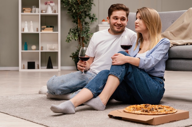 テレビを見たり、ワインを飲んだりするカップル