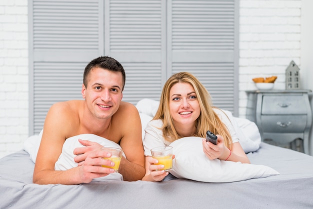 Free photo couple watching tv lying in bed